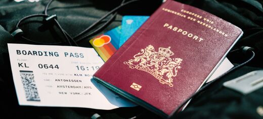 Reisepass, Boardingpass und Kreditkarten liegen auf schwarzem Stoff