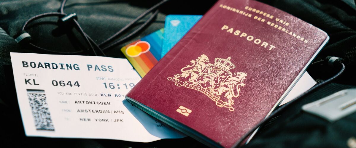 Reisepass, Boardingpass und Kreditkarten liegen auf schwarzem Stoff