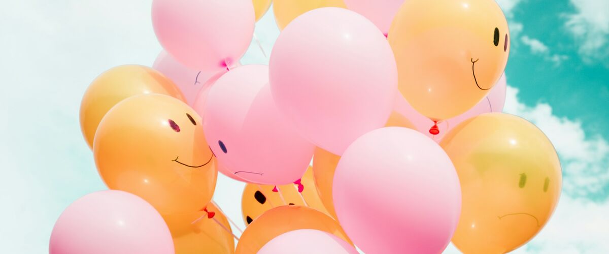 Symbolbild: Luftballons mit lachenden und traurigen Gesichern